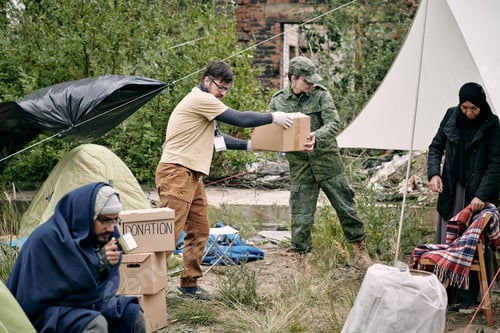 Preview: Young volunteer and representative of migration service spreading donation