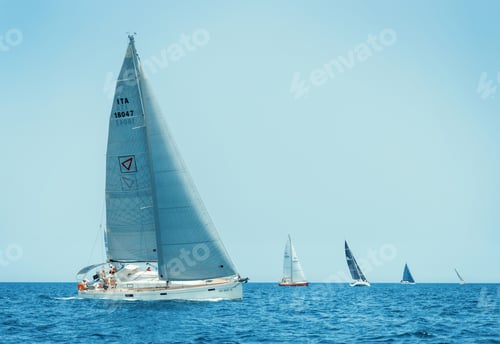 Preview: Sailboats races in regatta near Brindisi under blue sky. Crew members working together on deck