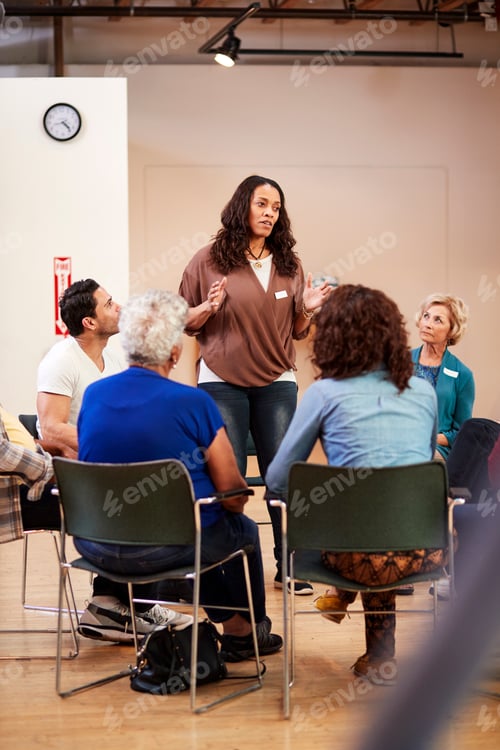 Preview: Woman Standing To Address Self Help Therapy Group Meeting In Community Center