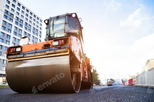 Preview: Orange Road Roller Compacting New Asphalt Pavement in a Metropolis Street During Daytime