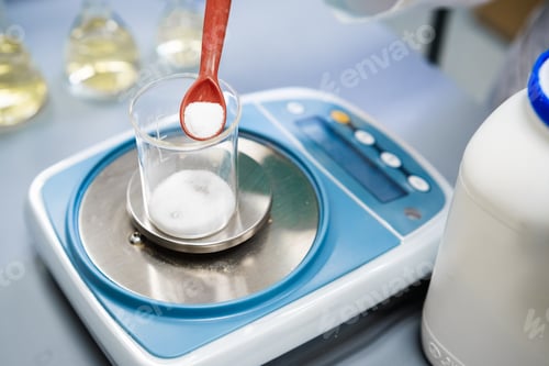 Preview: Using laboratory balances, a researcher weighs powder samples.