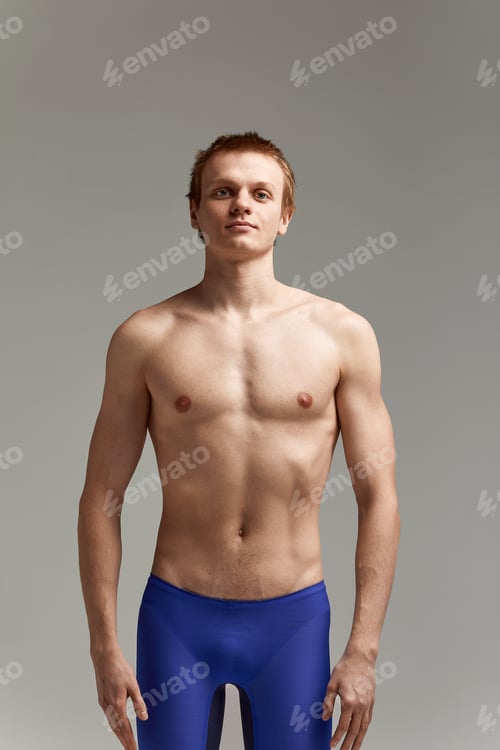 Preview: Young swimmer in excellent physical shape, on a gray background with copy space, call for sports