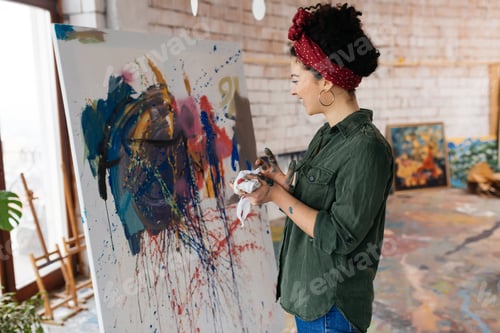 Preview: Young beautiful woman with dark curly hair dreamily drawing pict