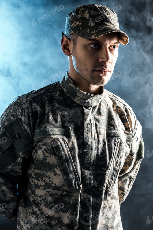 Preview: Serious Man in Camouflage Uniform with Moody Lighting