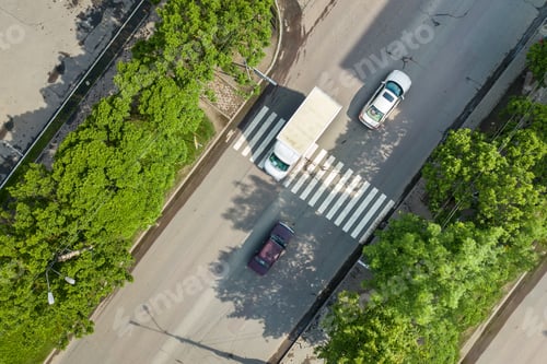 Preview: Top down aerial view of busy street with moving cars traffic and zebra road pedestrian crosswalk.