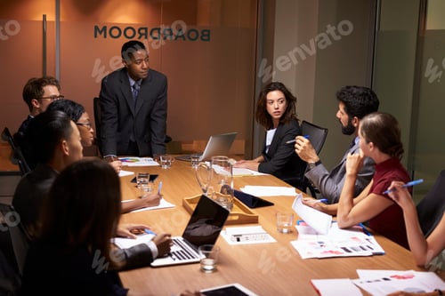 Preview: Black businessman standing to address colleagues at meeting