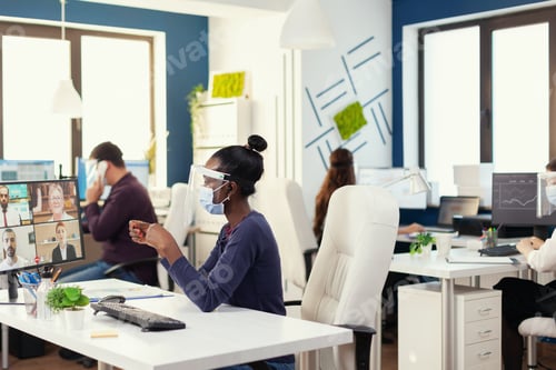 Preview: African businesswoman wearing wireless headphones during online call
