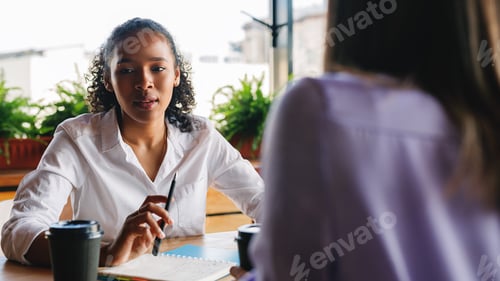Preview: Woman talking with colleague in cafe