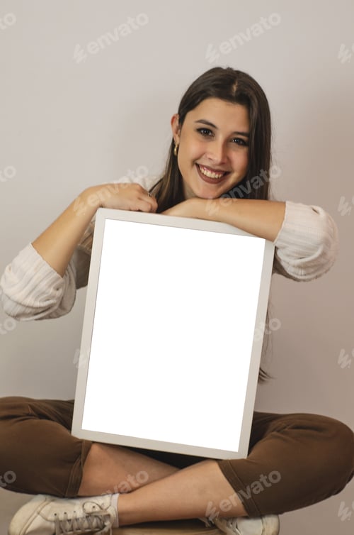 Preview: An attractive happy casual brunette sitting on a chair and leaning on an empty frame with arms