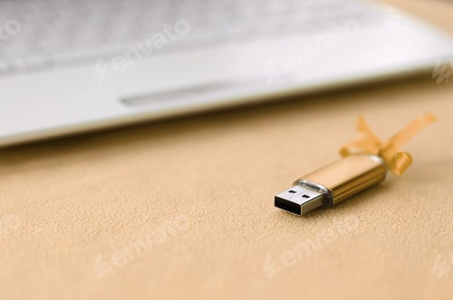 Preview: Orange usb flash memory card with a bow lies on a blanket of soft and furry li
