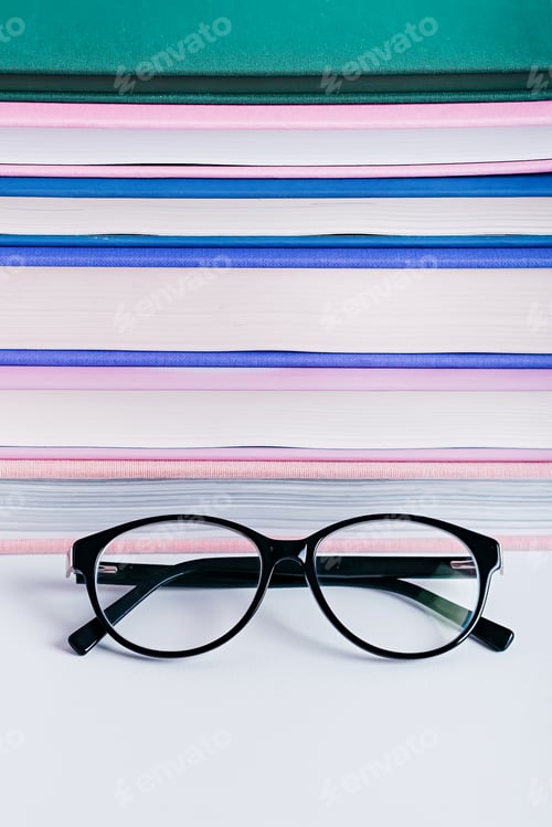 Preview: Close up of reading eyeglasses on books background