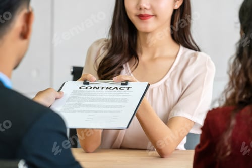 Preview: Senior Asian Manager submitting the contract document to Young Asian woman