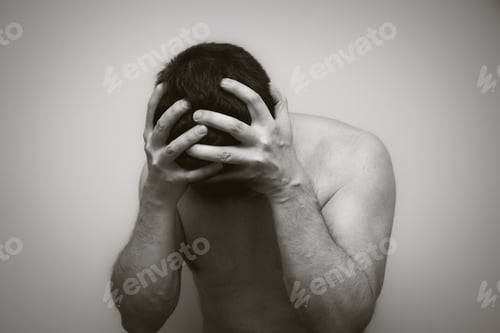 Preview: Monochrome shot of an upset man holding his head