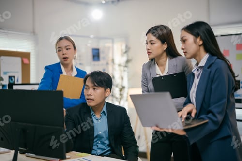 Preview: Team of young asian professionals are having a discussion while reviewing data on a computer screen.