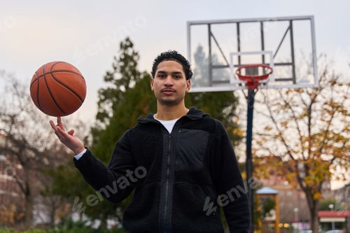 Preview: Young man spinning basketball on finger at street court