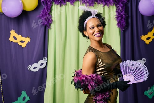 Preview: Happy black woman on Mardi Gras celebration festival looking at camera.