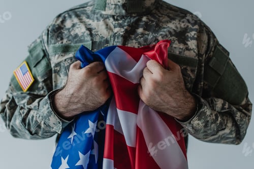 Preview: cropped view of American soldier holding flag of United States during memorial day isolated on grey