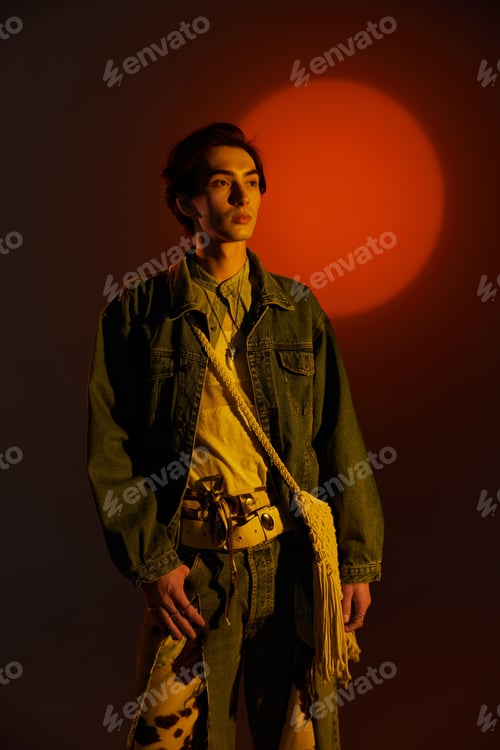 Preview: Fashionable non binary individual posing against a vivid sunset background