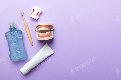 Preview: Mouthwash and other oral hygiene products on colored table top view with copy space