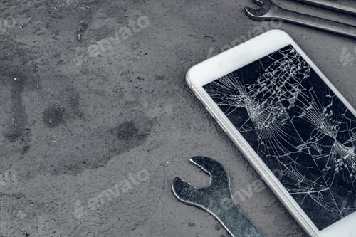 Preview: Crashed smartphone with repairing tools on grey background