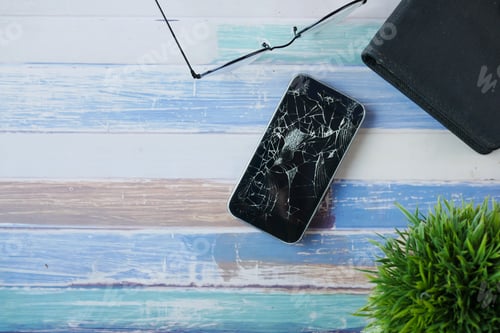 Preview: Top view of broken smart phone on color background