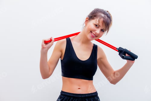 Preview: Smiling Woman Exercising with Resistance Band Indoors