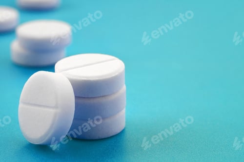 Preview: A few white tablets lie on a bright blue background surface