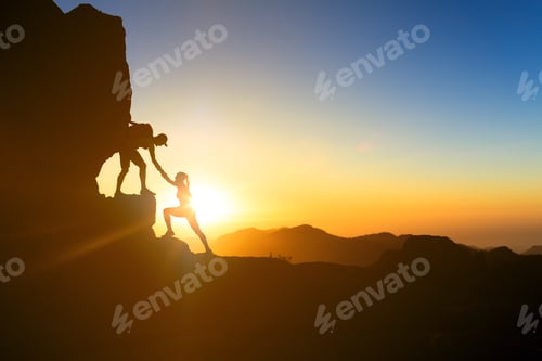 Preview: Teamwork couple climbing helping hand