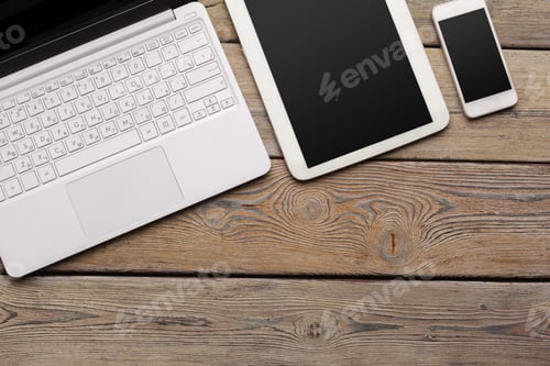 Preview: Open laptop with digital tablet and white smartphone close up top view