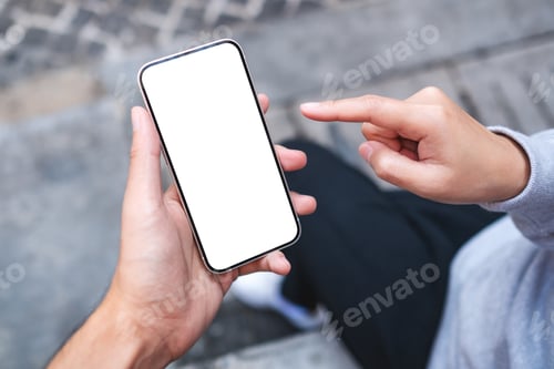 Preview: A couple people holding and looking at the same mobile phone with blank desktop screen