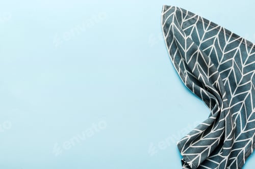 Preview: top view with blue kitchen napkin isolated on table background. Folded cloth