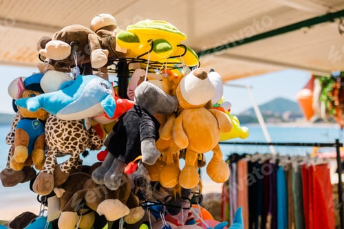 Preview: Plush animal toys hanging at seaside souvenir. Children merchandise