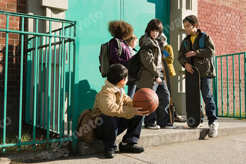 Preview: Group of kids with a basketball and a skateboard chatting by the school gates
