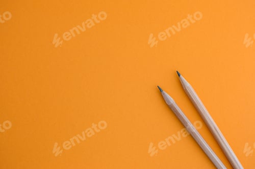 Preview: Two pencils on a yellow background.