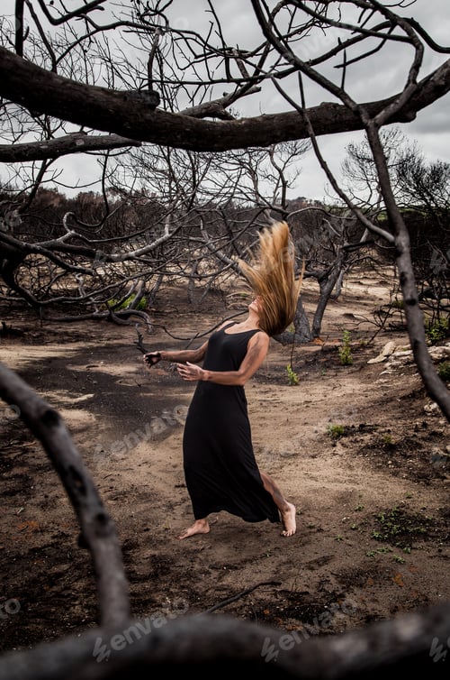 Preview: Woman posing on ground near dry trees