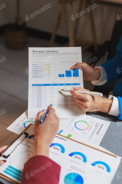 Preview: Financial advisors reviewing mortgage calculator documents and charts