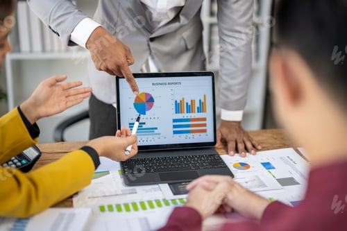 Preview: A group of people are looking at a laptop with a pie chart on it