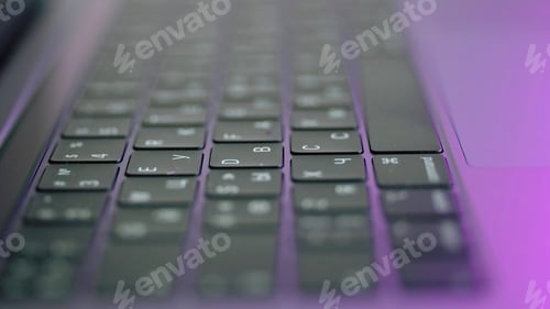 Preview: Side view of laptop or computer details, black keyboard with white symbols. Action. Extreme close up