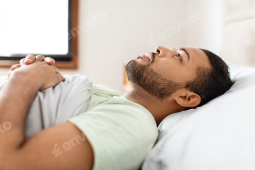 Preview: Man resting in bed with hands crossed