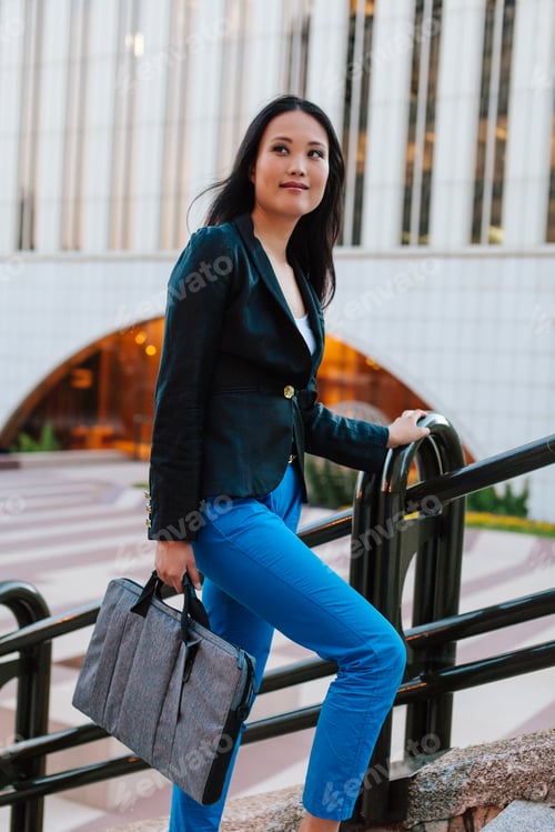 Preview: Asian businesswoman walking in street in downtown