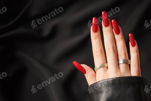 Preview: Hands of a young girl with red manicure on nails