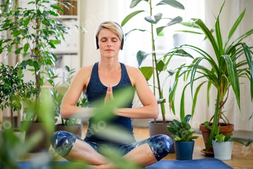 Preview: Front view of young woman indoors at home, doing yoga exercise