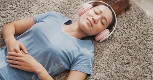 Preview: woman with casual wear headphone lay down on carpet floor listen music calm.