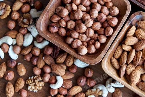 Preview: Wooden bowl with mixed nuts on table top view. Healthy food and snack