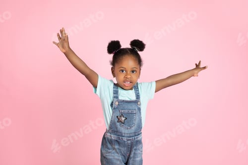 Preview: Portrait of cute little african kid girl in jeans overalls