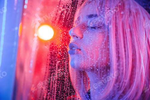 Preview: Feeling good, sensual look. Stylish woman with white hair is behind wet transparent plastic sheet