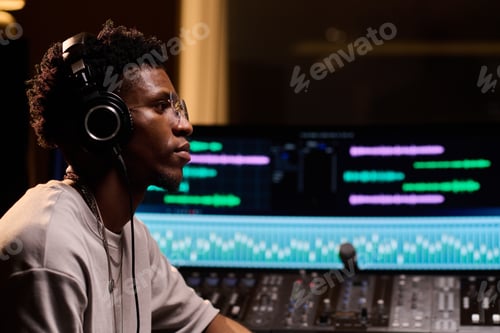 Preview: Young Adult Black Man Wearing Headphones Working in Music Recording Studio