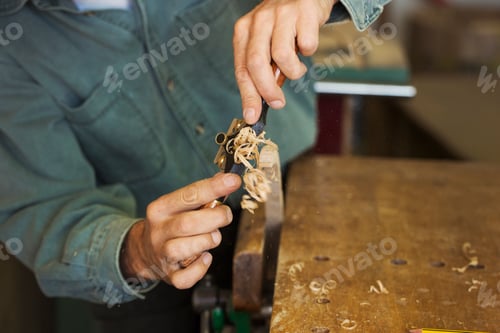 Preview: A craftsman using a spokeshave with blade to trim a piece of wood in a clamp.