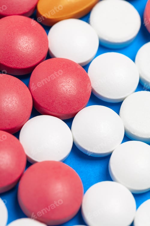 Preview: set of multi-colored tablets and capsules on a blue background