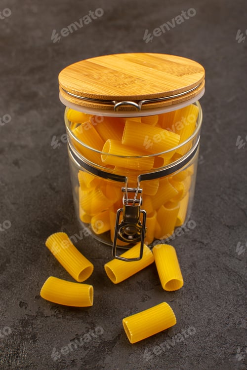 Preview: a front view italian dry pasta yellow raw inside bowl isolated on the dark background italian pasta